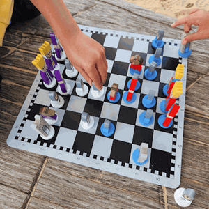 Educational wooden cartoon chess set for kids with colorful, playful pieces on a black and white board.