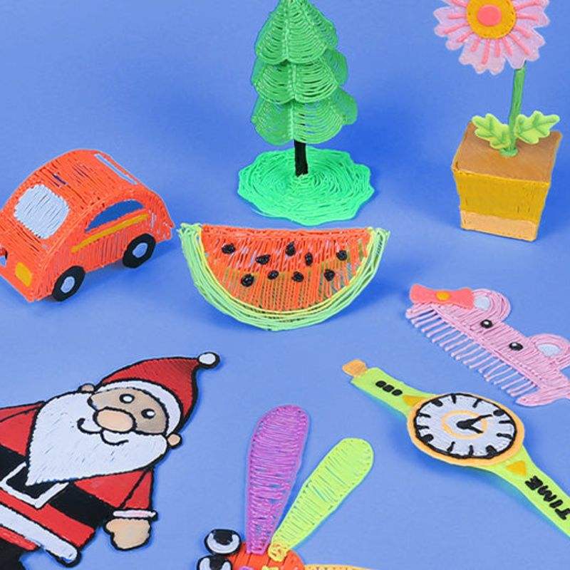3D Magic Pen Set creating colorful 3D designs including a car, watermelon, tree, flower, Santa, comb, and clock on blue background