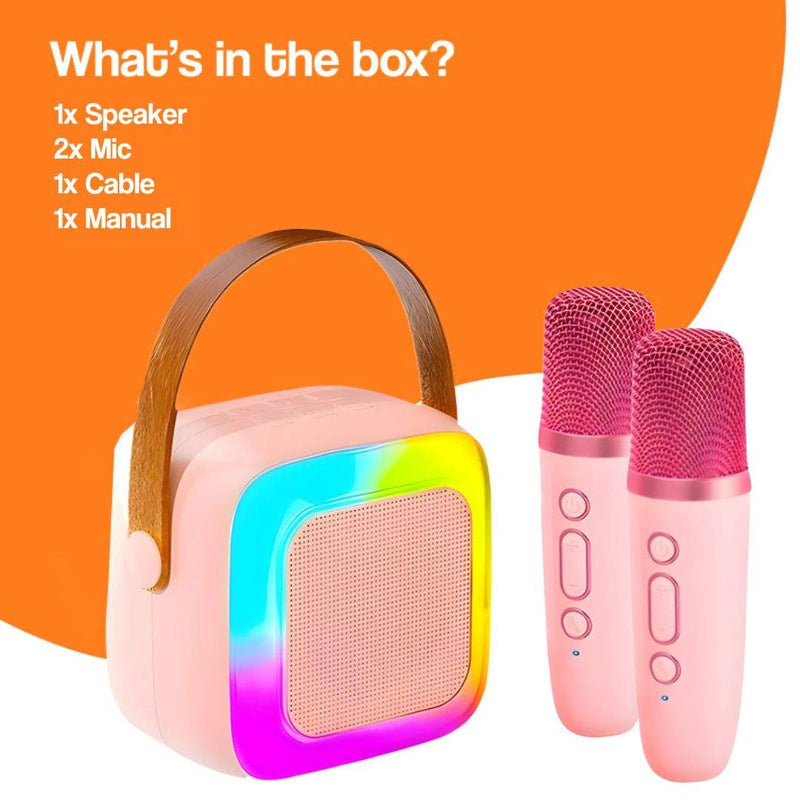 Family Fun Karaoke Machine with speaker, two pink microphones, cable, and manual against orange background